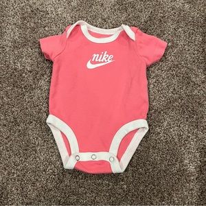 Pink and White Nike Onesie with a White Nike Swoosh